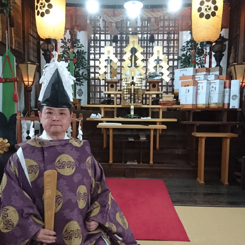 A Shinto priest in front of a Shinto shrine